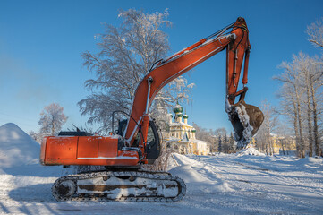 Excavator covered with snow at a construction site.
