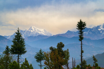 Mountain peak in the mountains. Panoramic view of the snow-covered Himalayan mountain ranges and Nanda Devi peak in the middle of a hill station called Gwaldham in Uttarakhand, India. 