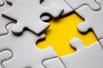 Close up view of missing jigsaw puzzle on yellow background. Copy space.