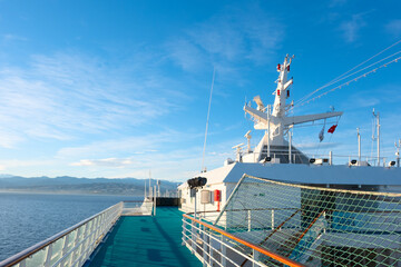 View from the upper open deck of a cruise ship on a bright sunny day against the background of a...