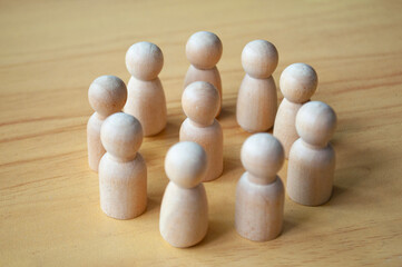 A wooden doll surrounded by other dolls. Representing either leadership or harassment