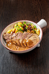 pork with baked potatoes and sauce