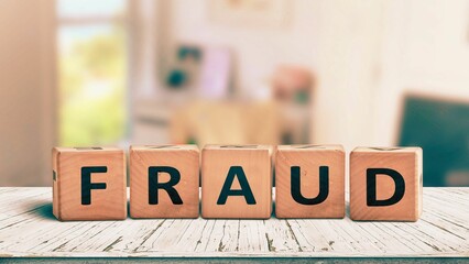 Fraud sign made of wooden blocks on a desk.