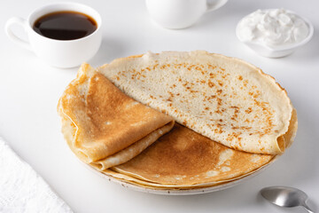Thin pancakes in a plate. Concept of delicious breakfast or Maslenitsa