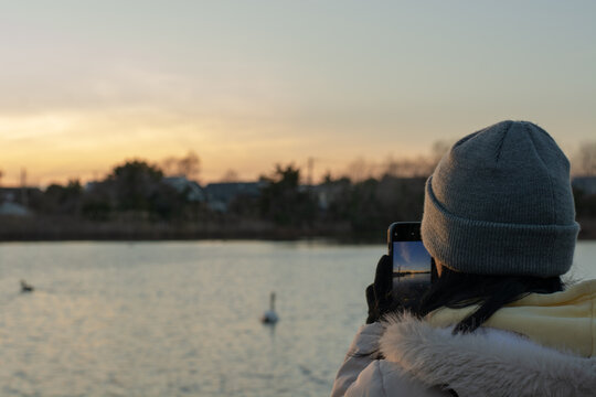 Young woman photographing the sunset
