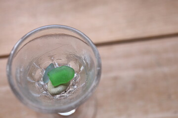 グラスに入れた緑色のシーグラス