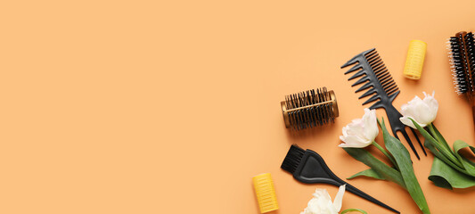 Hairdresser tools and tulip flowers on orange background with space for text