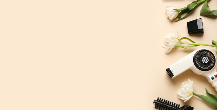 Hairdresser tools and tulip flowers on beige background with space for text