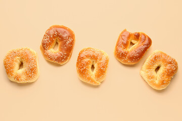 Tasty bagels with sesame seeds on beige background