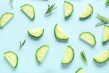 Slices of cucumber with rosemary on turquoise background