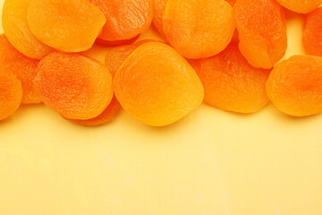 Tasty dried apricots on orange background