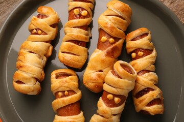 Cute sausage mummies on plate, closeup. Halloween party food