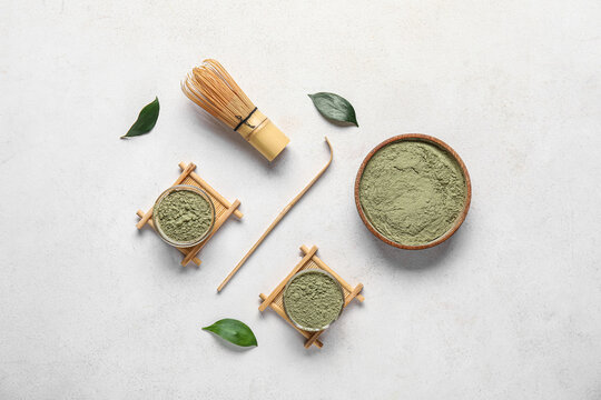 Composition with powdered matcha tea and accessories on light background