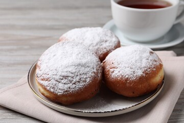 Delicious sweet buns and cup of tea on table, closeup
