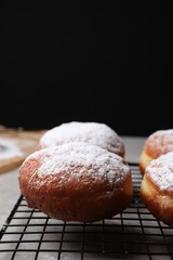 Delicious sweet buns on table against black background, space for text