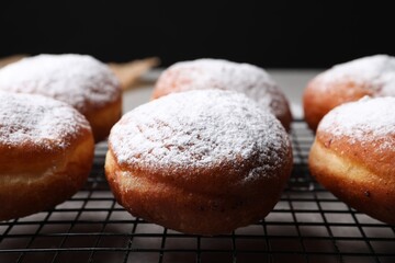 Delicious sweet buns on table against black background, closeup