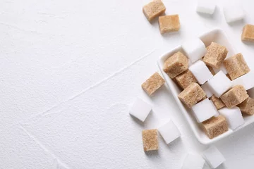 Fotobehang Different sugar cubes in bowl on white table, top view. Space for text © New Africa