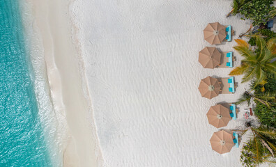 Amazing aerial tourism top view paradise beach landscape beds chairs umbrellas close to amazing tropic sea. White sand and blue crystal clear sea for luxury summer vacation holiday banner background