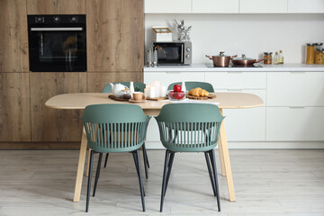 Interior of modern kitchen with table served for breakfast