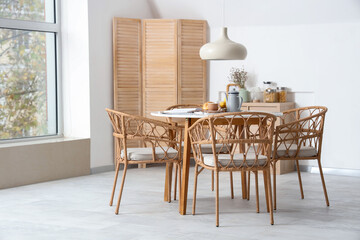 Interior of light room with dining table served for breakfast