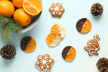 Chocolate dipped dried orange slices and sweet Christmas cookies on light blue background
