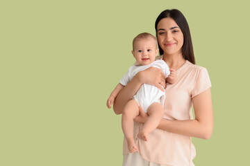 Happy mother with her little baby on green background