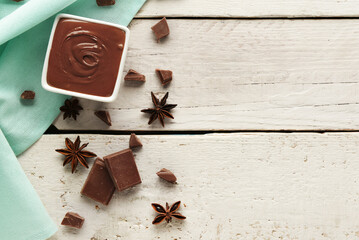 Composition with tasty melted chocolate on white wooden background