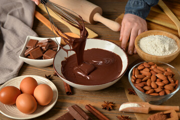Woman preparing tasty melted chocolate at table