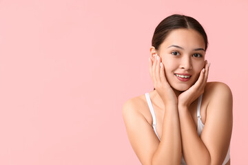 Beautiful young Asian woman on pink background