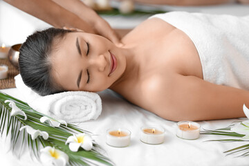 Obraz na płótnie Canvas Young Asian woman getting massage in spa salon, closeup