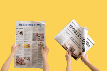 Naklejka premium Women with newspapers on yellow background