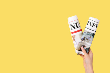 Woman with rolled newspapers on yellow background - obrazy, fototapety, plakaty