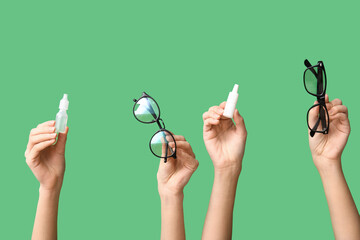 Female hands with eye drops and eyeglasses on green background. Glaucoma awareness concept