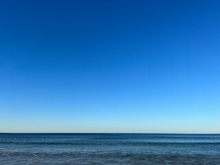 Blue seascape background, clear blue sky and blue sea horizon