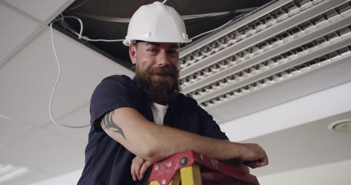 Man, face of electrician and light installation with construction, engineer and renovation for power supply. Industrial, manual labor and maintenance, electricity and cable with service in portrait