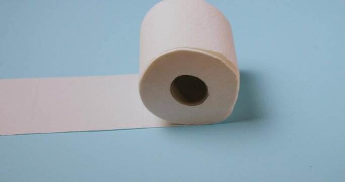 toilet paper roll rolling on blue background
