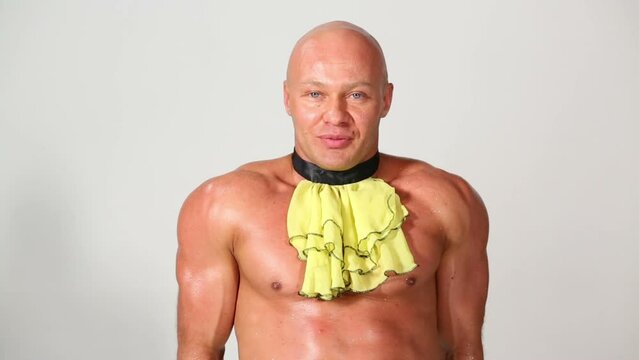 Bald muscular man in dicky and cuffs poses smiling 