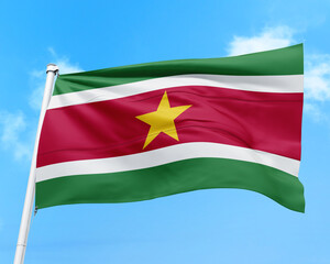 Obraz premium Suriname flag fluttering in the wind on sky.