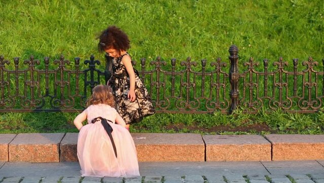 Girl walks on curb and other girl comes up to her 