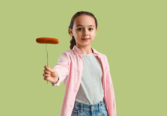 Cute little girl with tasty sausage on green background