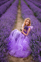young woman inhales the scent of lavender in Provence.