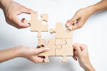 Asian group of business people holding a jigsaw puzzle pieces.