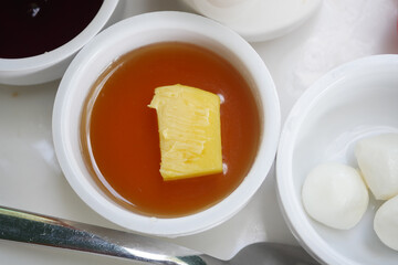 slice of fresh butter and honey in a container 