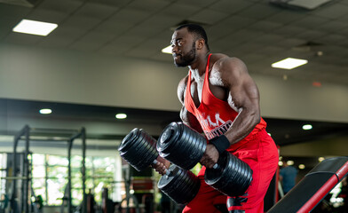 Fototapeta na wymiar Bodybuilding man workout with barbells. Muscular black guy training hard in gym.