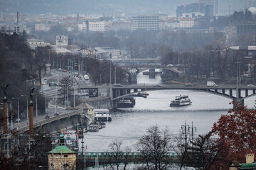 A cityscape view of the of the historic old medieval city of Prague. There re bridges with traffic...
