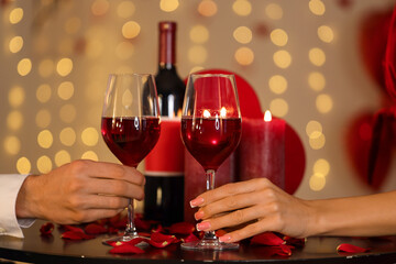 Young couple with glasses of wine at home on Valentine's Day, closeup