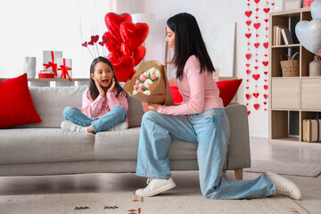 Young Asian woman greeting her little daughter with Valentine's day at home - obrazy, fototapety, plakaty