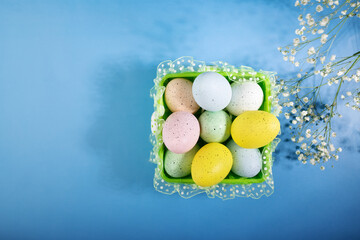 Happy Easter, eggs in a basket, spring flowers, blue background, festive decor