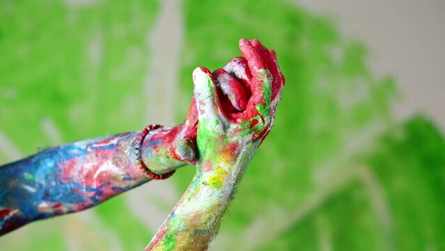 Two painted hands move, rotate and palms fold together. 