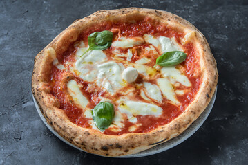 Pizza Margarita with  buffalo mozzarella cheese Takeaway food. Top view. On a black stone background.